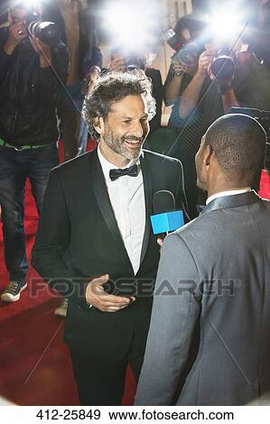 Stock Photo - Celebrity being interviewed and photographed by paparazzi at event. Fotosearch