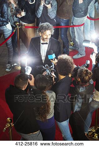 Stock Photograph - Celebrity being interviewed and photographed by paparazzi at event. Fotosearch