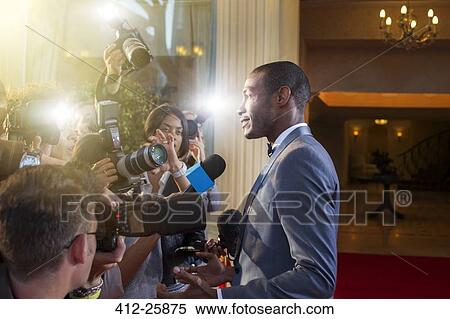 Celebrity being interviewed and photographed by paparazzi at red carpet event View Large Photo Image Stock Photography - Celebrity being interviewed and photographed by paparazzi at red carpet event. Fotosearch