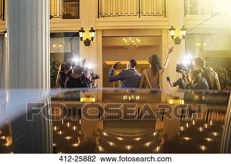 Celebrity couple arriving and waving at paparazzi photographers at event View Large Photo Image Stock Image - Celebrity couple arriving and waving at paparazzi photographers at event. Fotosearch