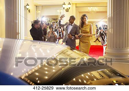 Celebrity couple waving at paparazzi photographers and leaving event View Large Photo Image Stock Photo - Celebrity couple waving at paparazzi photographers and leaving event. Fotosearch