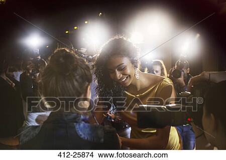 Picture - Celebrity signing autographs for fans at event. Fotosearch