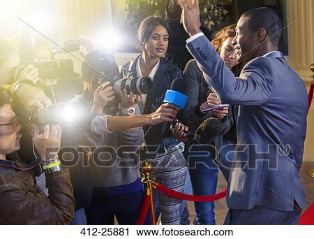 Celebrity waving at paparazzi photographers at red carpet event View Large Photo Image Stock Image - Celebrity waving at paparazzi photographers at red carpet event. Fotosearch