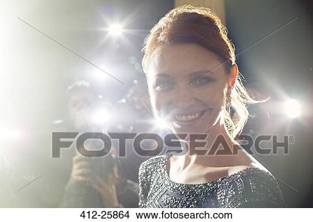 Picture - Close up portrait of smiling celebrity being photographed at paparazzi event. Fotosearch