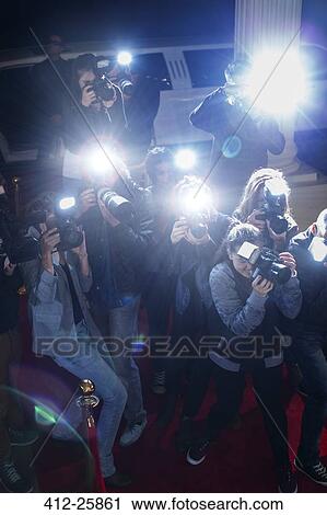 Paparazzi photographers pointing cameras at red carpet event View Large Photo Image Stock Image - Paparazzi photographers pointing cameras at red carpet event. Fotosearch