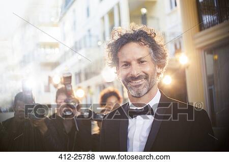 Stock Photo - Portrait of celebrity at event with paparazzi in background. Fotosearch