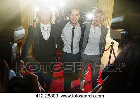 Portrait of smiling celebrities in a row arriving at red carpet event View Large Photo Image Stock Photo - Portrait of smiling celebrities in a row arriving at red carpet event. Fotosearch