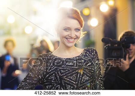 Portrait of smiling celebrity being photographed by paparazzi at event View Large Photo Image Stock Image - Portrait of smiling celebrity being photographed by paparazzi at event. Fotosearch