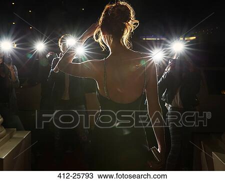 Stock Image - Silhouette of celebrity being photographed by paparazzi. Fotosearch