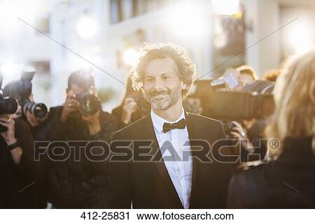 Smiling celebrity being photographed by paparazzi at event View Large Photo Image Stock Image - Smiling celebrity being photographed by paparazzi at event. Fotosearch