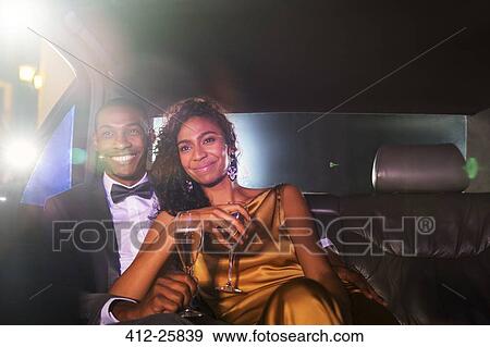 Smiling celebrity couple drinking champagne inside limousine outside event View Large Photo Image Stock Photo - Smiling celebrity couple drinking champagne inside limousine outside event. Fotosearch