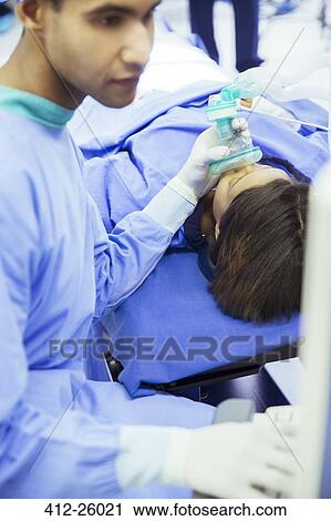 Anesthesiologist holding oxygen mask over patient’s face in operating room View Large Photo Image Stock Image - Anesthesiologist holding oxygen mask over patient’s face in operating room . Fotosearch
