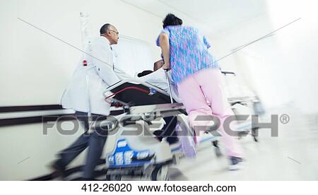 Doctor and nurse rushing patient on stretcher in hospital corridor View Large Photo Image Stock Image - Doctor and nurse rushing patient on stretcher in hospital corridor. Fotosearch