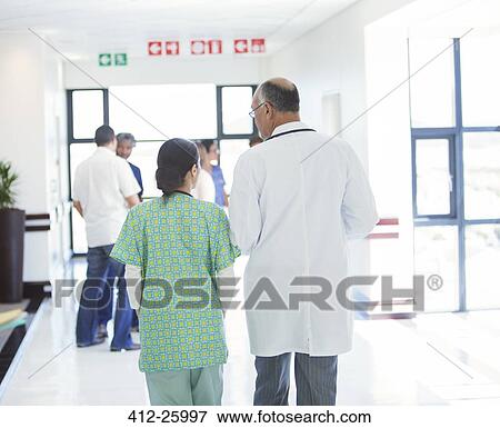Doctor and nurse walking in hospital corridor View Large Photo Image Stock Photo - Doctor and nurse walking in hospital corridor. Fotosearch