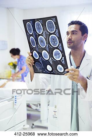 Stock Photo - Doctor reviewing MRI scans in hospital room. Fotosearch