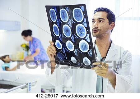 Doctor reviewing MRI scans in hospital room View Large Photo Image Stock Photo - Doctor reviewing MRI scans in hospital room. Fotosearch
