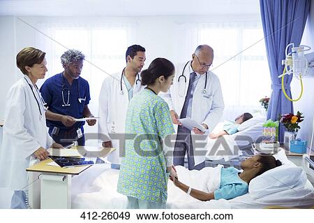 Doctors and nurse making rounds in hospital room View Large Photo Image Stock Photo - Doctors and nurse making rounds in hospital room. Fotosearch