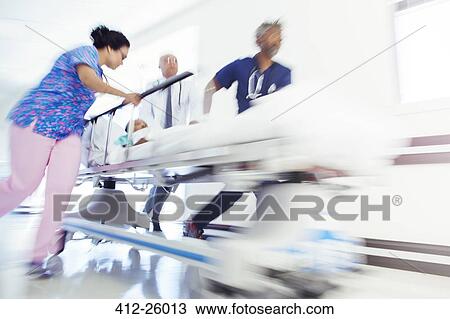 Doctors and nurse rushing patient in stretcher in hospital corridor View Large Photo Image Stock Image - Doctors and nurse rushing patient in stretcher in hospital corridor. Fotosearch