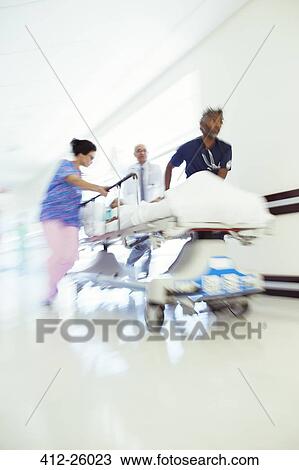 Doctors and nurse rushing patient in stretcher in hospital corridor View Large Photo Image Stock Image - Doctors and nurse rushing patient in stretcher in hospital corridor. Fotosearch