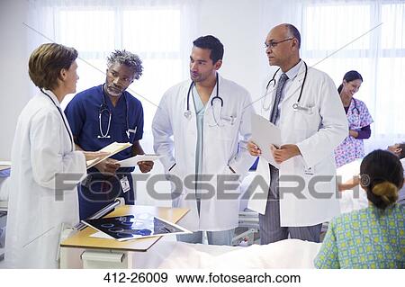 Doctors making rounds and consulting in hospital room View Large Photo Image Stock Photo - Doctors making rounds and consulting in hospital room. Fotosearch
