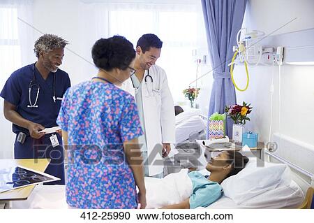 Doctors making rounds and talking with patient in hospital View Large Photo Image Stock Image - Doctors making rounds and talking with patient in hospital. Fotosearch
