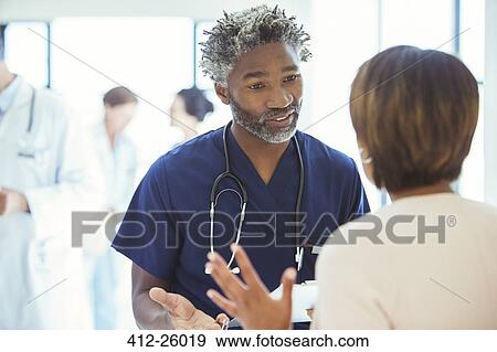 Doctors talking face to face in hospital View Large Photo Image Stock Photo - Doctors talking face to face in hospital. Fotosearch