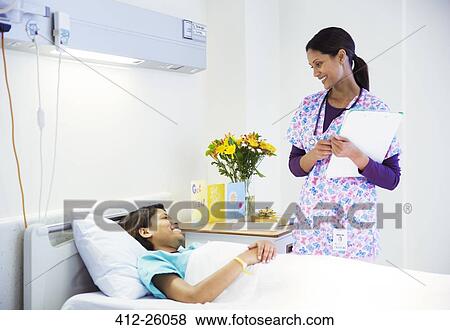 Nurse talking to patient in hospital room View Large Photo Image Stock Photo - Nurse talking to patient in hospital room. Fotosearch