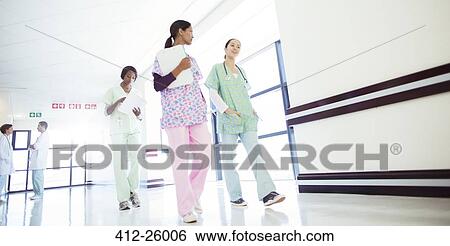 Nurses talking and walking in hospital corridor View Large Photo Image Stock Photograph - Nurses talking and walking in hospital corridor. Fotosearch