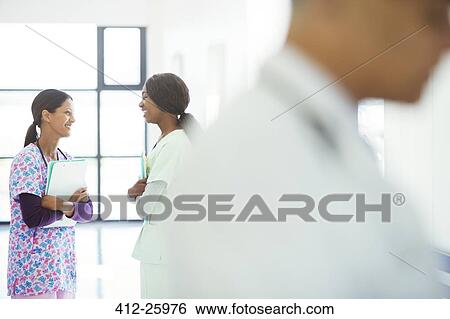 Nurses talking in hospital corridor View Large Photo Image Stock Photograph - Nurses talking in hospital corridor. Fotosearch