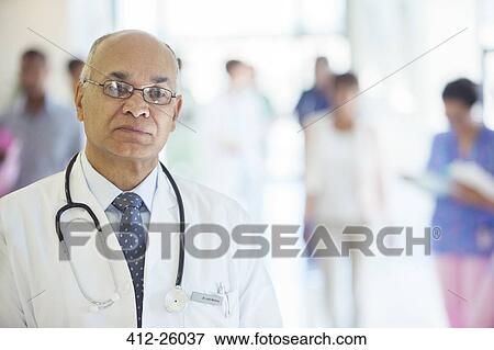 Portrait of confident doctor in hospital corridor View Large Photo Image Stock Photo - Portrait of confident doctor in hospital corridor. Fotosearch