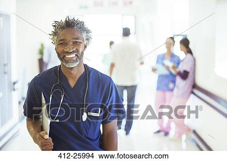 Portrait of smiling doctor in hospital corridor View Large Photo Image Picture - Portrait of smiling doctor in hospital corridor. Fotosearch