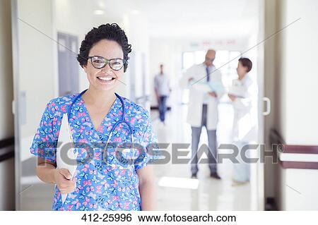 Portrait of smiling nurse in hospital corridor View Large Photo Image Stock Photograph - Portrait of smiling nurse in hospital corridor. Fotosearch