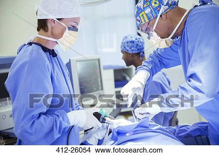 Surgeons performing surgery in operating room View Large Photo Image Picture - Surgeons performing surgery in operating room. Fotosearch