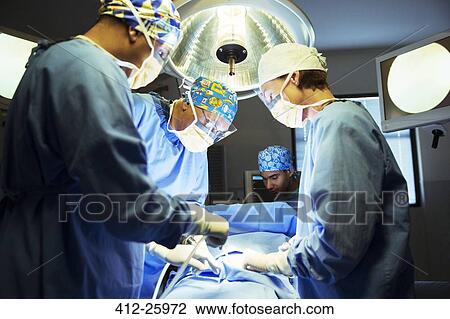 Surgeons performing surgery in operating room View Large Photo Image Stock Image - Surgeons performing surgery in operating room. Fotosearch