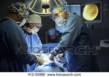 Surgeons performing surgery in operating room View Large Photo Image Stock Image - Surgeons performing surgery in operating room. Fotosearch