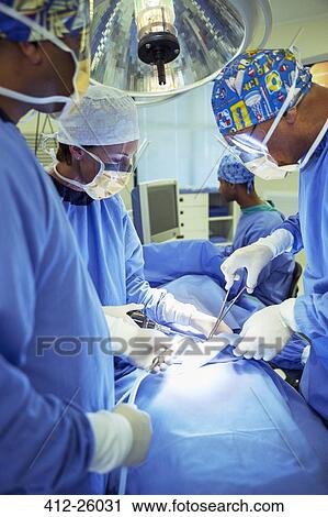 Surgeons performing surgery in operating room View Large Photo Image Stock Image - Surgeons performing surgery in operating room. Fotosearch
