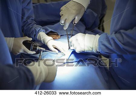 Surgeons performing surgery in operating room View Large Photo Image Stock Image - Surgeons performing surgery in operating room. Fotosearch