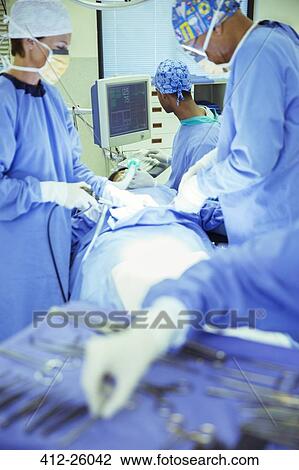 Surgeons performing surgery in operating room View Large Photo Image Stock Image - Surgeons performing surgery in operating room. Fotosearch