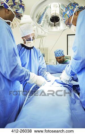 Surgeons performing surgery in operating room View Large Photo Image Stock Photo - Surgeons performing surgery in operating room. Fotosearch