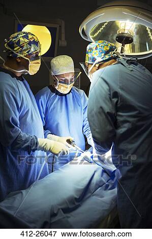 Surgeons performing surgery in operating room View Large Photo Image Stock Photo - Surgeons performing surgery in operating room. Fotosearch