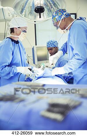 Surgeons performing surgery in operating room View Large Photo Image Stock Photo - Surgeons performing surgery in operating room. Fotosearch