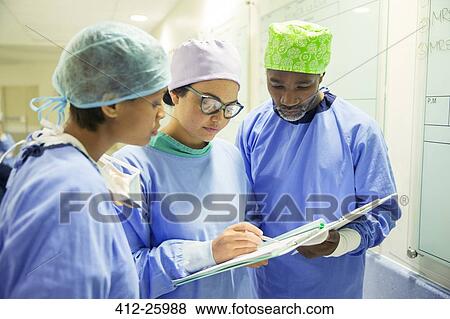 Surgeons reviewing medical record in hospital View Large Photo Image Stock Photo - Surgeons reviewing medical record in hospital. Fotosearch