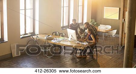 Casual business people meeting around computer in office View Large Photo Image Stock Photography - Casual business people meeting around computer in office. Fotosearch