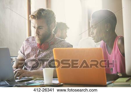 Casual business people working at laptops in office View Large Photo Image Stock Image - Casual business people working at laptops in office. Fotosearch