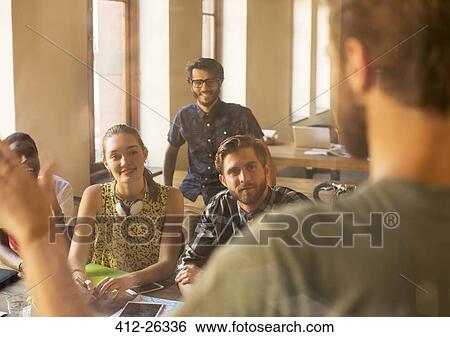 Stock Photograph - Casual businessman leading meeting in office. Fotosearch