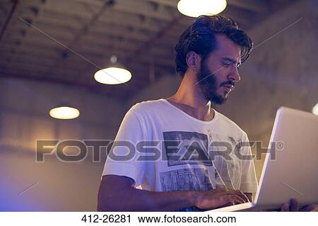 Casual businessman using laptop in office View Large Photo Image Stock Image - Casual businessman using laptop in office. Fotosearch