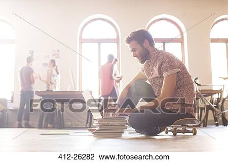 Casual businessman working at laptop from skateboard View Large Photo Image Stock Image - Casual businessman working at laptop from skateboard. Fotosearch