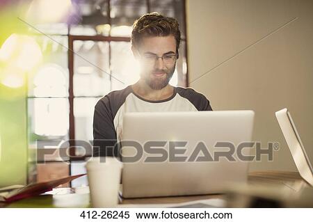 Casual businessman working at laptop View Large Photo Image Stock Photography - Casual businessman working at laptop. Fotosearch