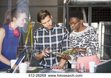 Creative business people looking at book in meeting View Large Photo Image Stock Photo - Creative business people looking at book in meeting. Fotosearch