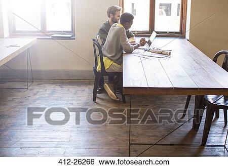 Stock Photograph - Creative business people working at laptop in office. Fotosearch